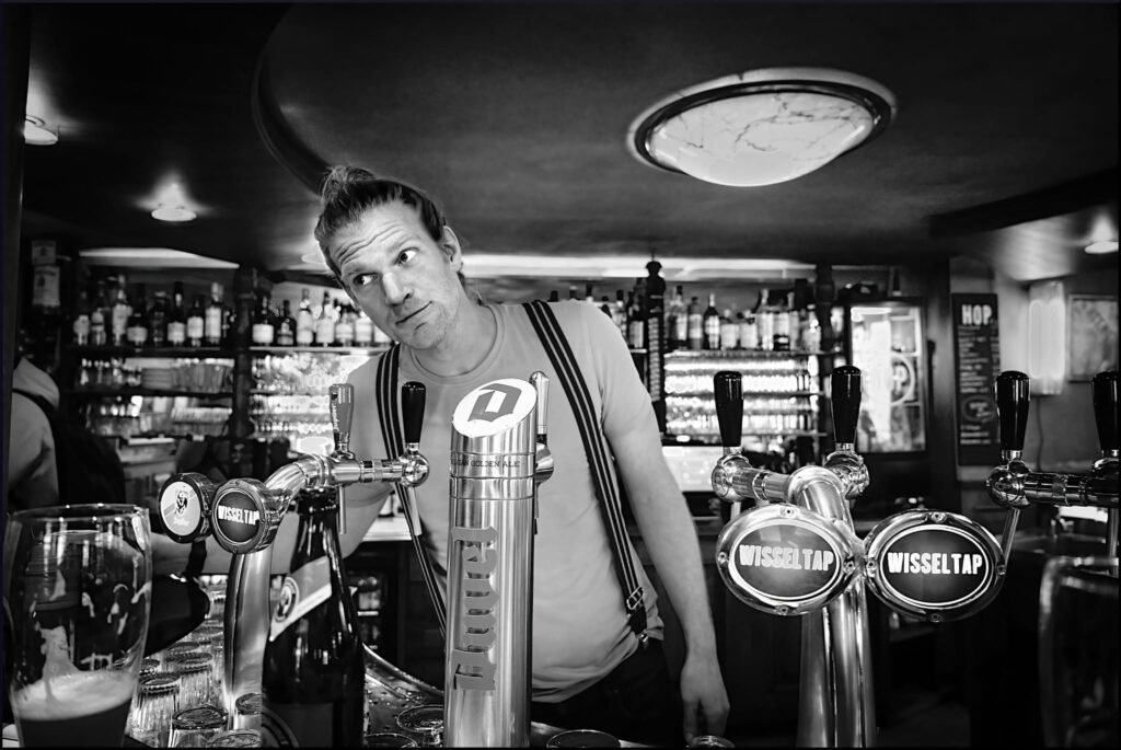 Tobias Bosman achter de bar met tap op de voorgrond